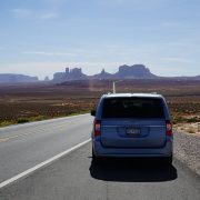 Our car with Monument Valley in the distance, near the Arizona-Utah border